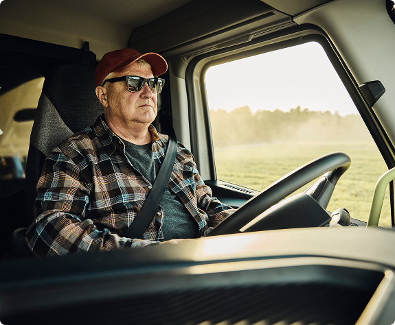 A view of a driver with his hands on the steering wheel.