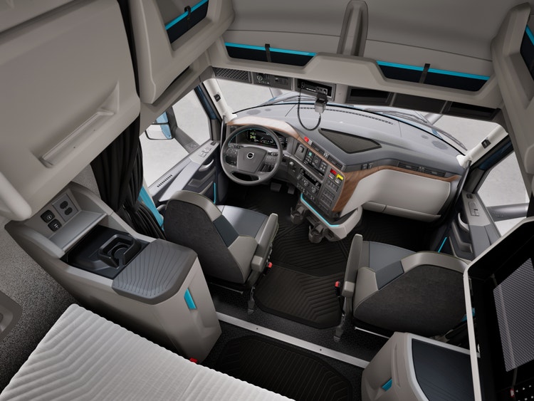 Interior view of a Volvo semi truck, featuring an ergonomic dashboard, premium seating, and a well-organized sleeper area