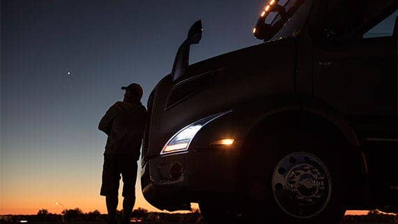 A person leaning on Volvo Truck VNL