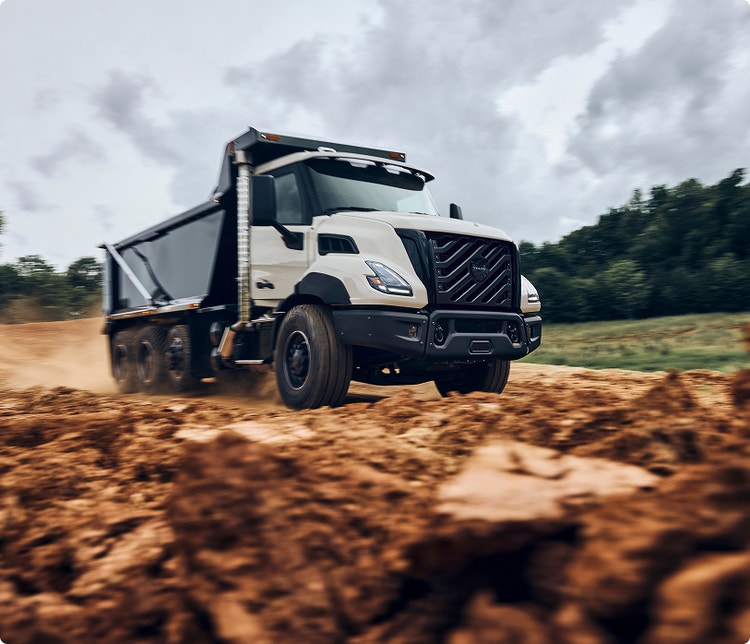 A sideview of a Volvo VNX on a rocky road.