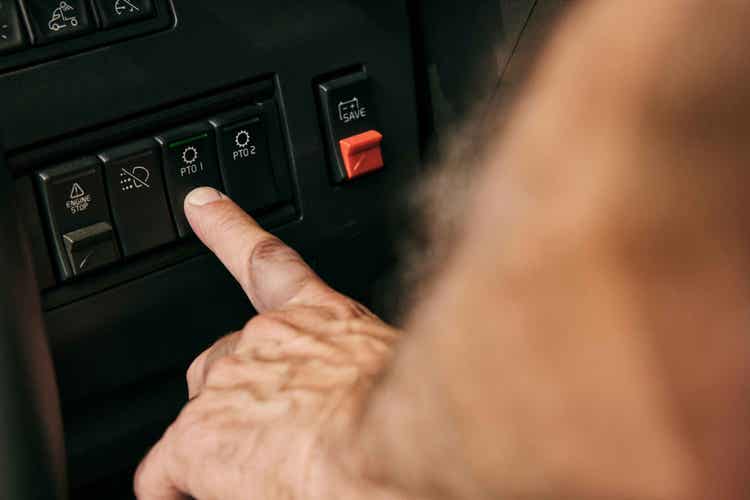 A finger pressing a button on the controls available on the Factory-installed PTOs