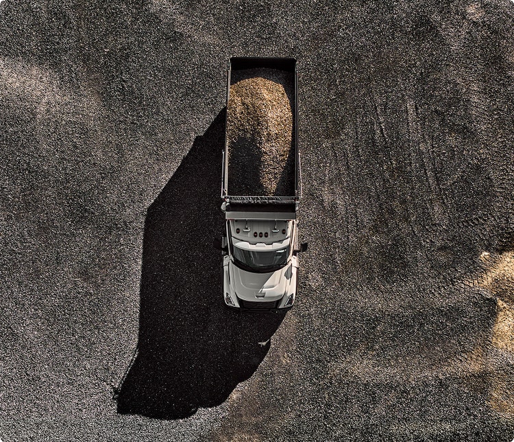 An above view of the Volvo VNX Dump truck with sand/gravel in the back.