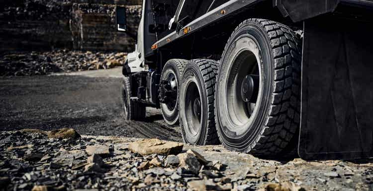 A view of the tires of the Volvo VNX on a rocky ground from the behind.