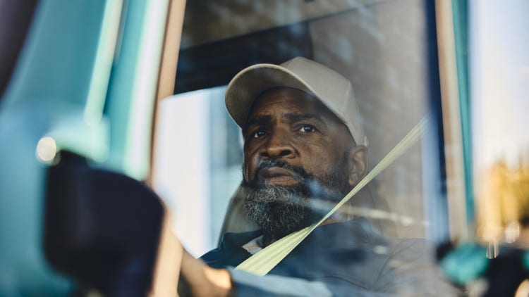 A Volvo truck driver seated behind the wheel, emphasizing confidence and reliability under the Volvo Gold Contract service plaAn for electric trucks