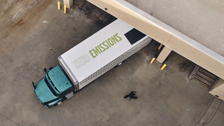 Overhead view of a Volvo VNR Electric truck parked at a loading dock, showcasing its 'Zero Emissions' branding.