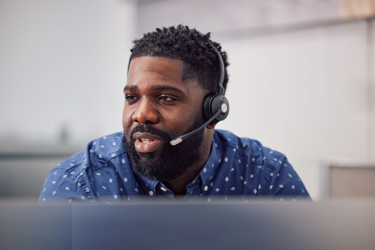 A customer support representative wearing a headset, ready to assist with Volvo VNX truck inquiries and services.