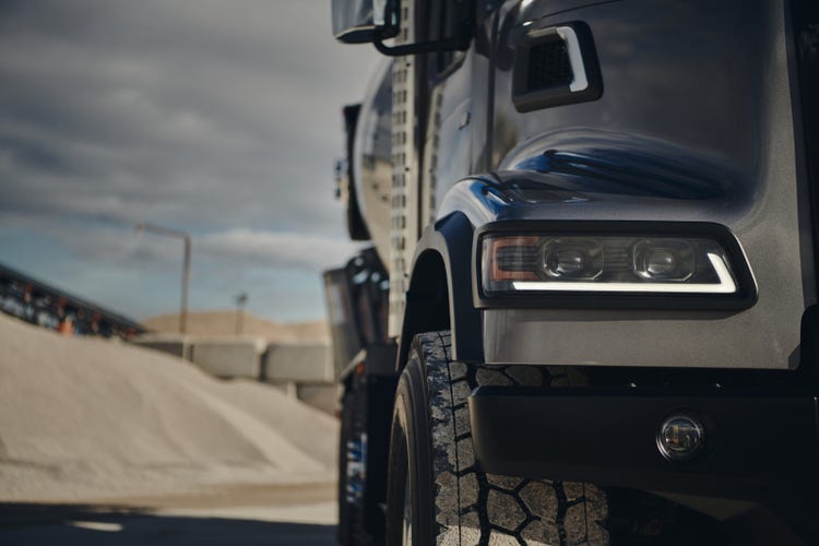 Close-up of a Volvo VHD truck's front headlight and durable tire.