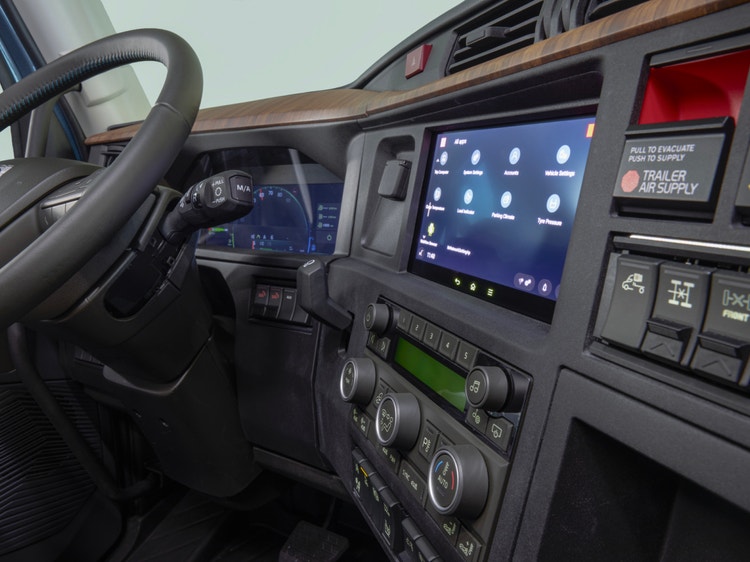 Volvo VNL truck interior showcasing the steering wheel, a digital dashboard, touchscreen interface, and detailed control panels.