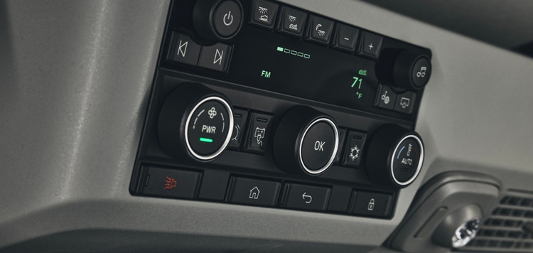 Volvo VNL dashboard controls with adjustable dials for temperature, fan power, and media playback, alongside a digital FM display.
