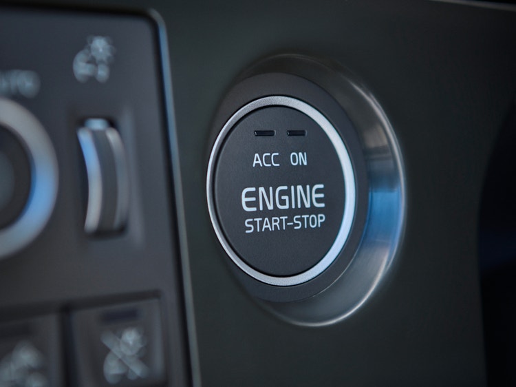 Volvo VNL dashboard featuring the engine start-stop button with bright text and adjacent control switches.