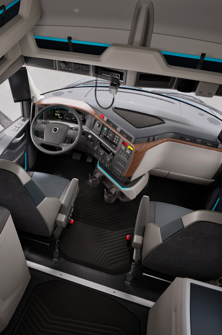 Overhead view of the Volvo VNL cab interior, highlighting the ergonomic steering wheel, digital dashboard, wood-trimmed accents, and comfortable seating.