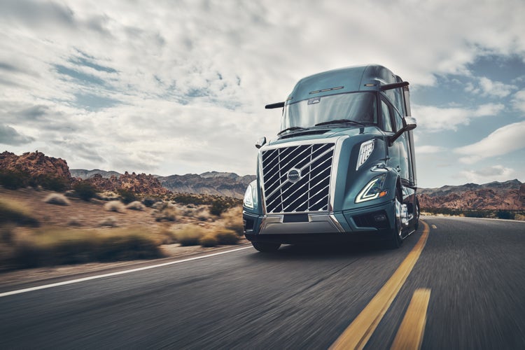 A Volvo VNL truck driving on a highway under a cloudy sky.