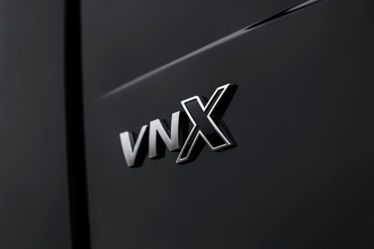Close-up of the VNX badge on the side of a black Volvo VNX truck.