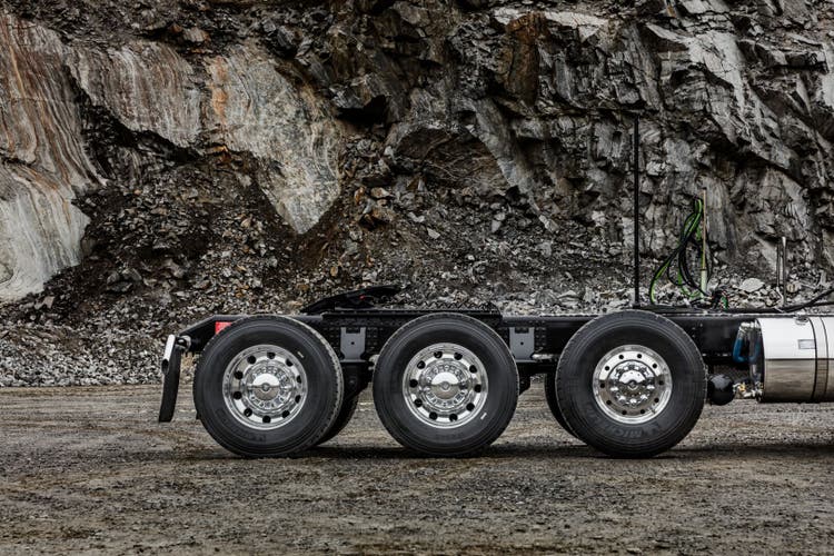 Close-up side view of the rear triple-axle configuration of a Volvo VNX truck, designed for superior stability and support in heavy-duty hauling.